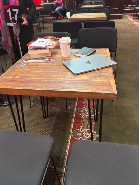 A table with a computer and a cup of coffee on itDescription automatically generated